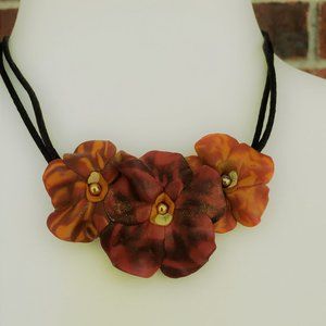 Faux leather flower necklace on a black cord